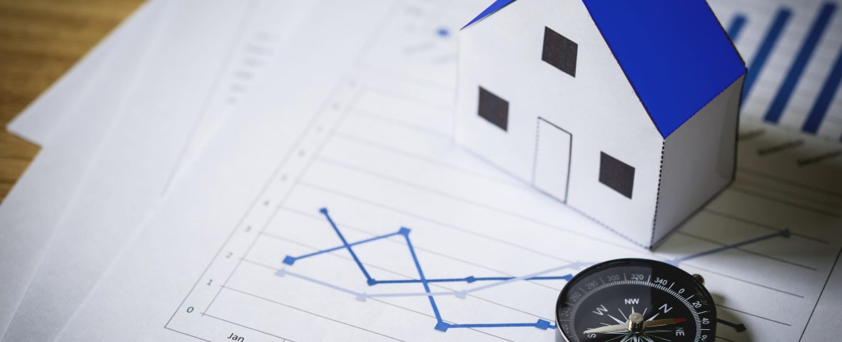 House model and compass on plan background, Real estate concept.